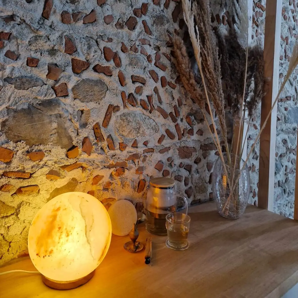 Lampe cosy allumée devant le mur de pierre du local Jeannelle